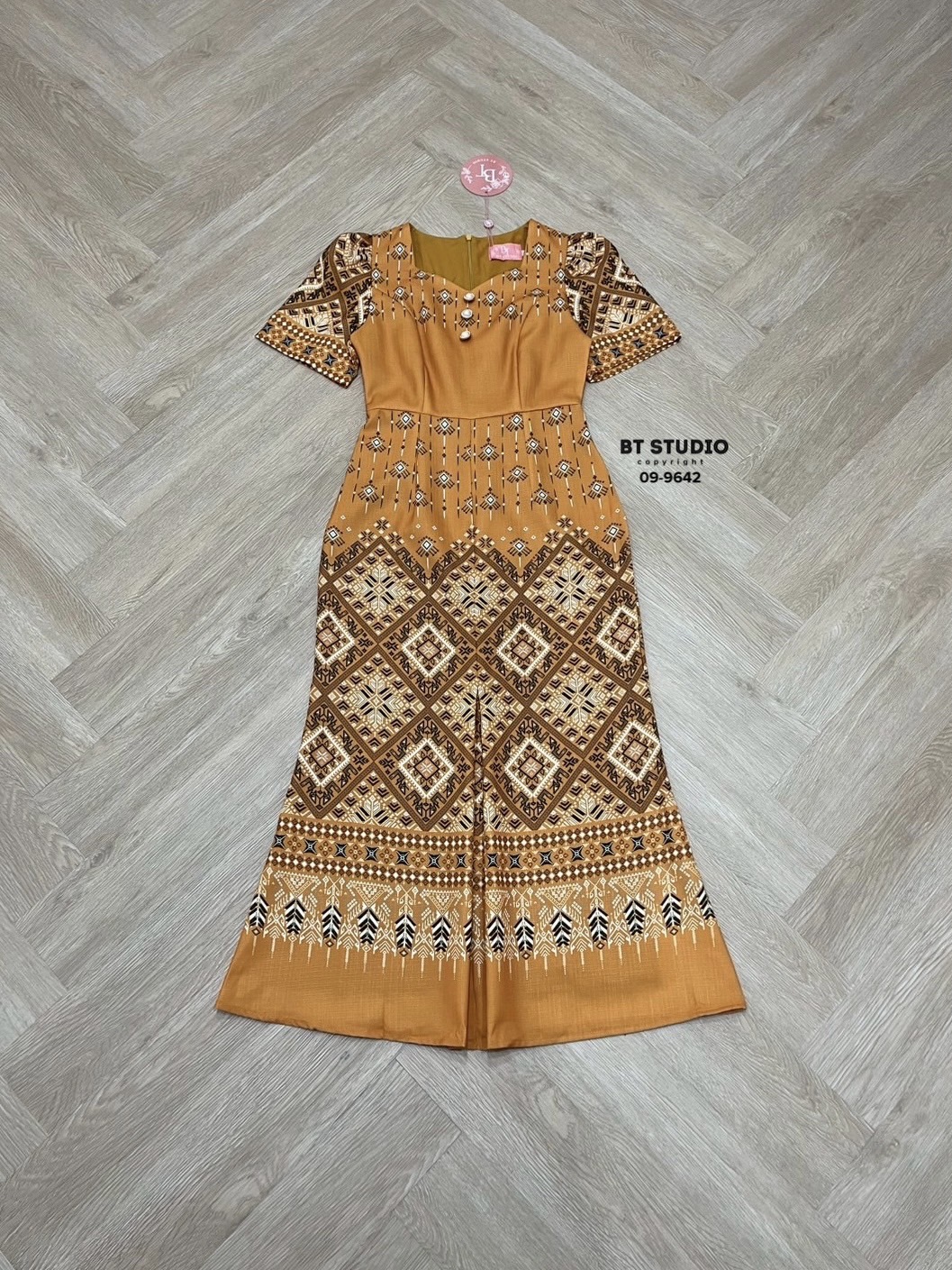 เดรสยาวผ้าไทยดีเทลแต่งคอเว้าเล็กน้อย แขนสั้น แต่งกระดุมมุก 3 เม็ดเรียงกัน ดีไซส์ผ้าพิมพ์ลายไทยประยุกต์ งานสวยเนื้อผ้าดีมีซับในคัตติ๊งสวยจ้า