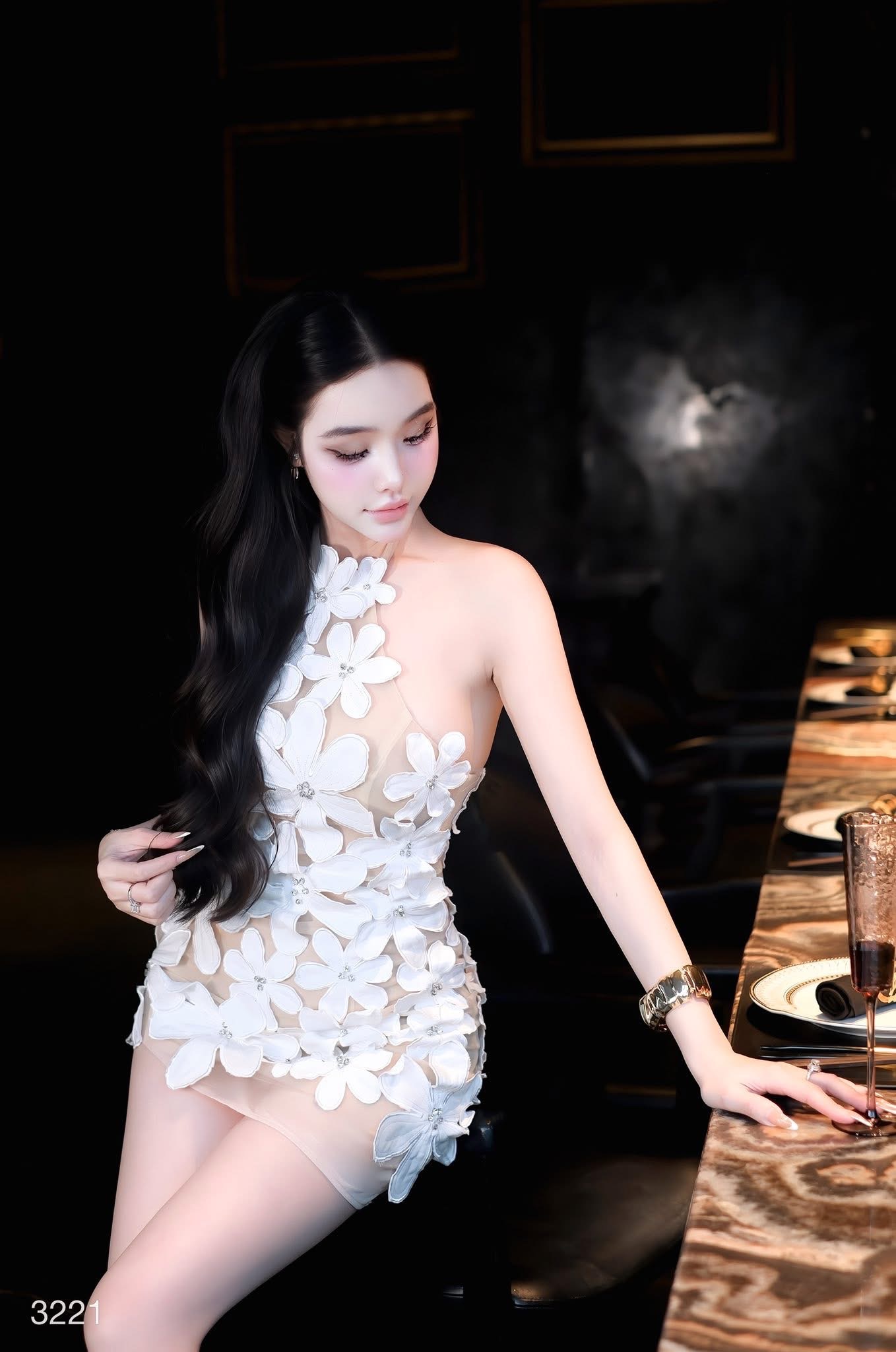 เดรสสั้นดีไซน์สุดโดดเด่นด้วยลายดอกไม้สามมิติทั้งตัว แต่งดอกไม้นูนขนาดเล็ก-ใหญ่ไล่ระดับจากช่วงคอลงมาถึงชายกระโปรง เพิ่มลูกเล่นด้วยการฝังคริสตัลเล็กกลางดอกช่วยสะท้อนแสงอย่างหรูหรา ดีไซน์ชายเดรสเฉียงดูชิคเปรี้ยวมาก ให้ลุคหวานปนเซ็กซี่อย่างลงตัว เ