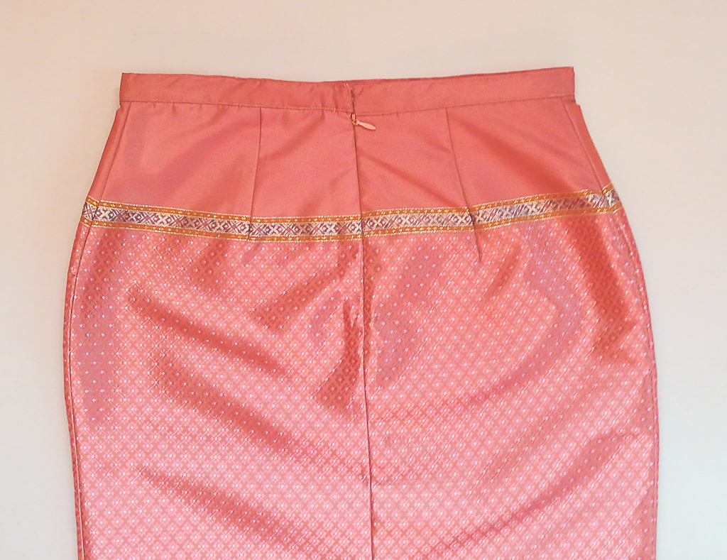 ผ้าถุงไหมสำเร็จรูป (สีชมพูอ่อน ลายสุโขทัย ทรงกระโปรง) งานตัดเย็บประณีต อัดผ้ากาวตามสีของผ้าถุง เนื้องานดีเกรด A (รอบเอว 30 นิ้ว)