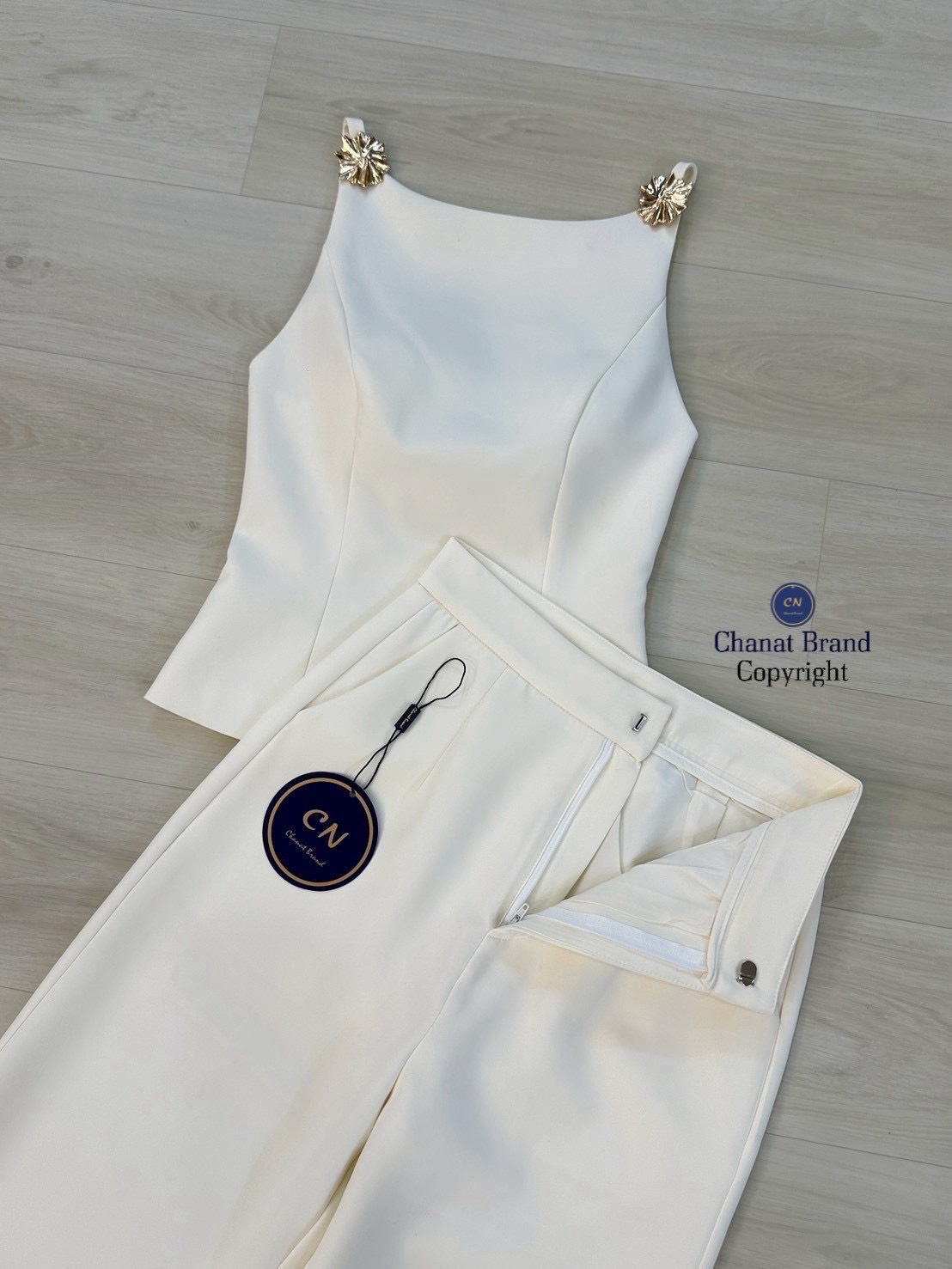 Set 2 ชิ้น เสื้อสายเดี่ยวสีครีม ช่วงสายด้านหน้าแต่งอะไหล่ดอกไม้สีทอง อกเสริมฟองน้ำ ดีเทลแต่งเว้าหลังบน ซิปหลังมีชับในตัว แมทซ์กับกางเกงขายาว สีเดียวกับชุด มีตะข้อและซิปหน้า กระเป๋าข้างใช้งานได้จริง งานสวย เนื้อผ้าดี คัตติ๊งเป๊ะคะ