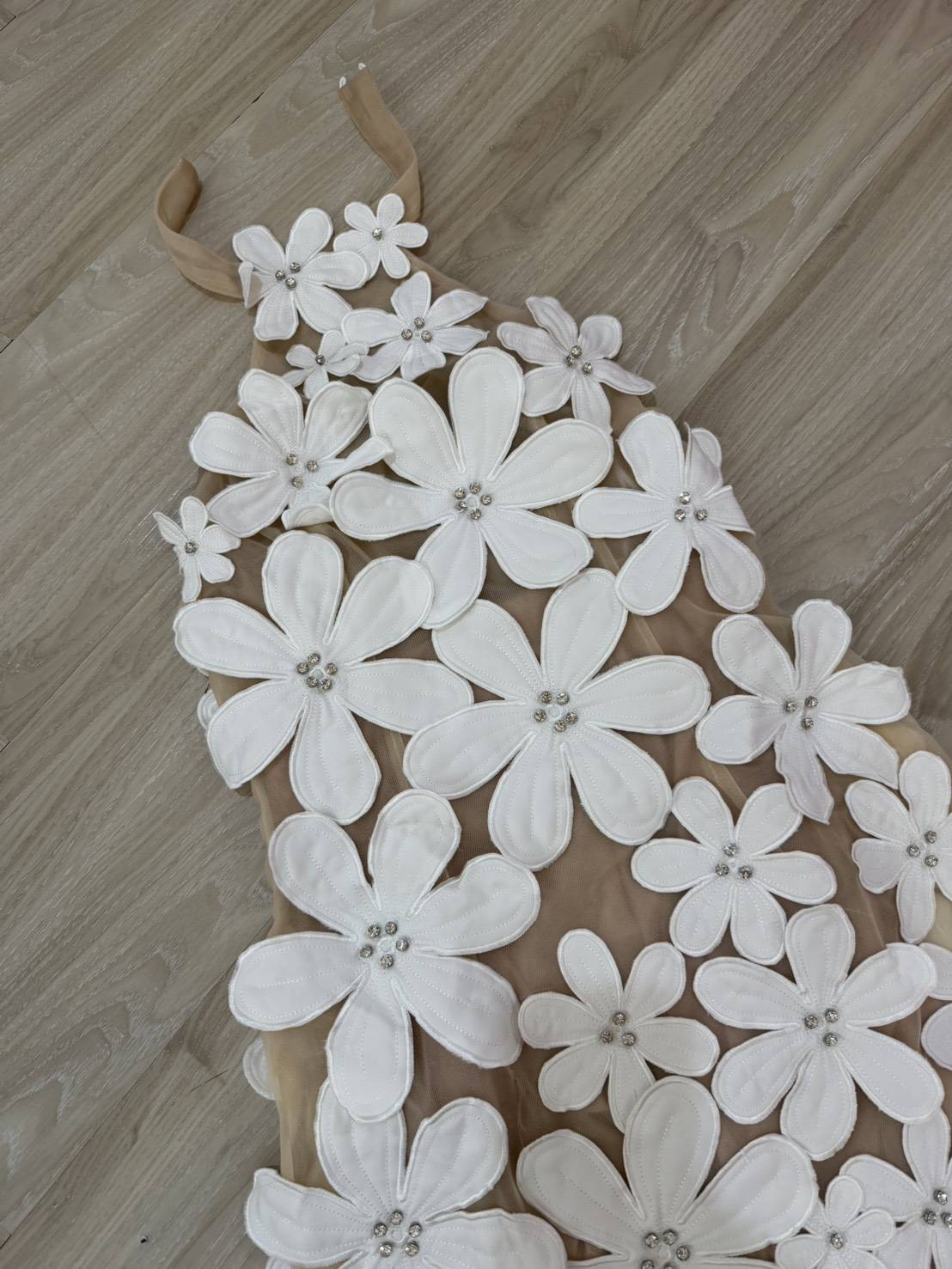 เดรสสั้นดีไซน์สุดโดดเด่นด้วยลายดอกไม้สามมิติทั้งตัว แต่งดอกไม้นูนขนาดเล็ก-ใหญ่ไล่ระดับจากช่วงคอลงมาถึงชายกระโปรง เพิ่มลูกเล่นด้วยการฝังคริสตัลเล็กกลางดอกช่วยสะท้อนแสงอย่างหรูหรา ดีไซน์ชายเดรสเฉียงดูชิคเปรี้ยวมาก ให้ลุคหวานปนเซ็กซี่อย่างลงตัว เ