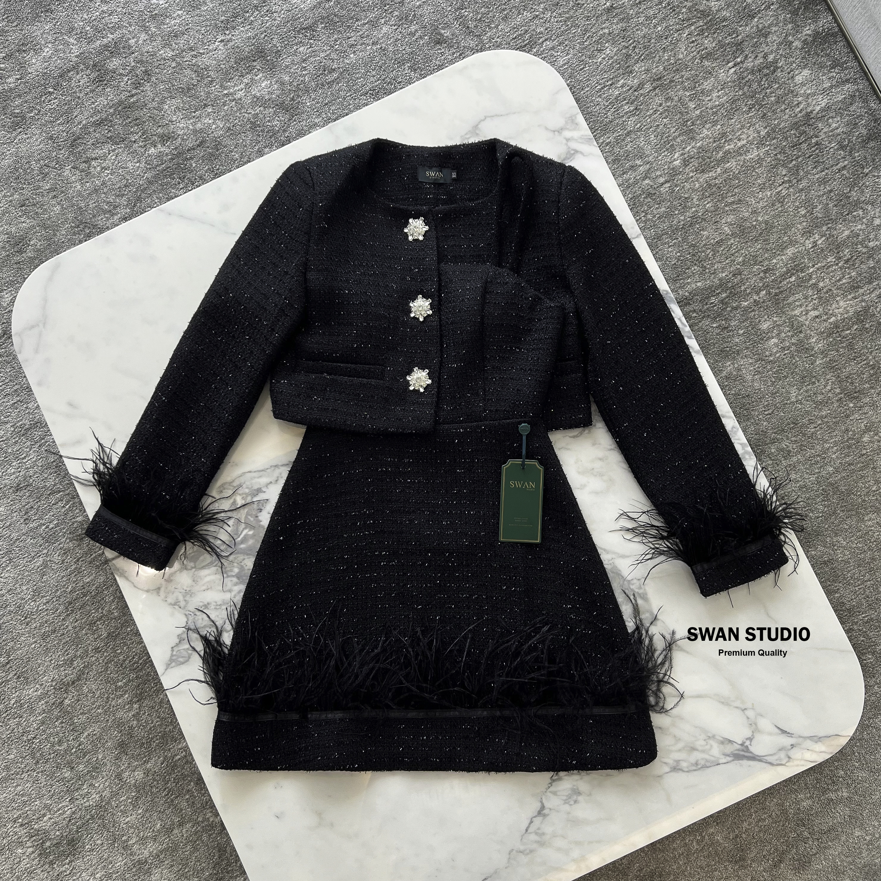 เซทเสื้อคลุมแขนยาวผ้าทวิตสีดำ แต่งกระดุมเพชรดอกไม้ ปลายแขนแต่งขนนก + มินิเดรสเกาะอก แต่งปลายเดรสด้วยขนนก สวยดูแพงมาก ห้ามพลาดค่า