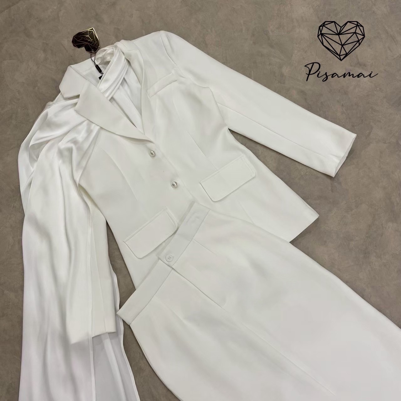 เซ็ตเสื้อสูทเบเซอร์สีขาวแขนยาว มีกิมมิคช่วงคอเป็นผ้าพาดหางปลายาว มาคู่กับกระโปรงทรงสอบสีขาว #pisamaibrand #ชุดไปงาน #ชุดทำบุญ #ceolook #ชุดสูท