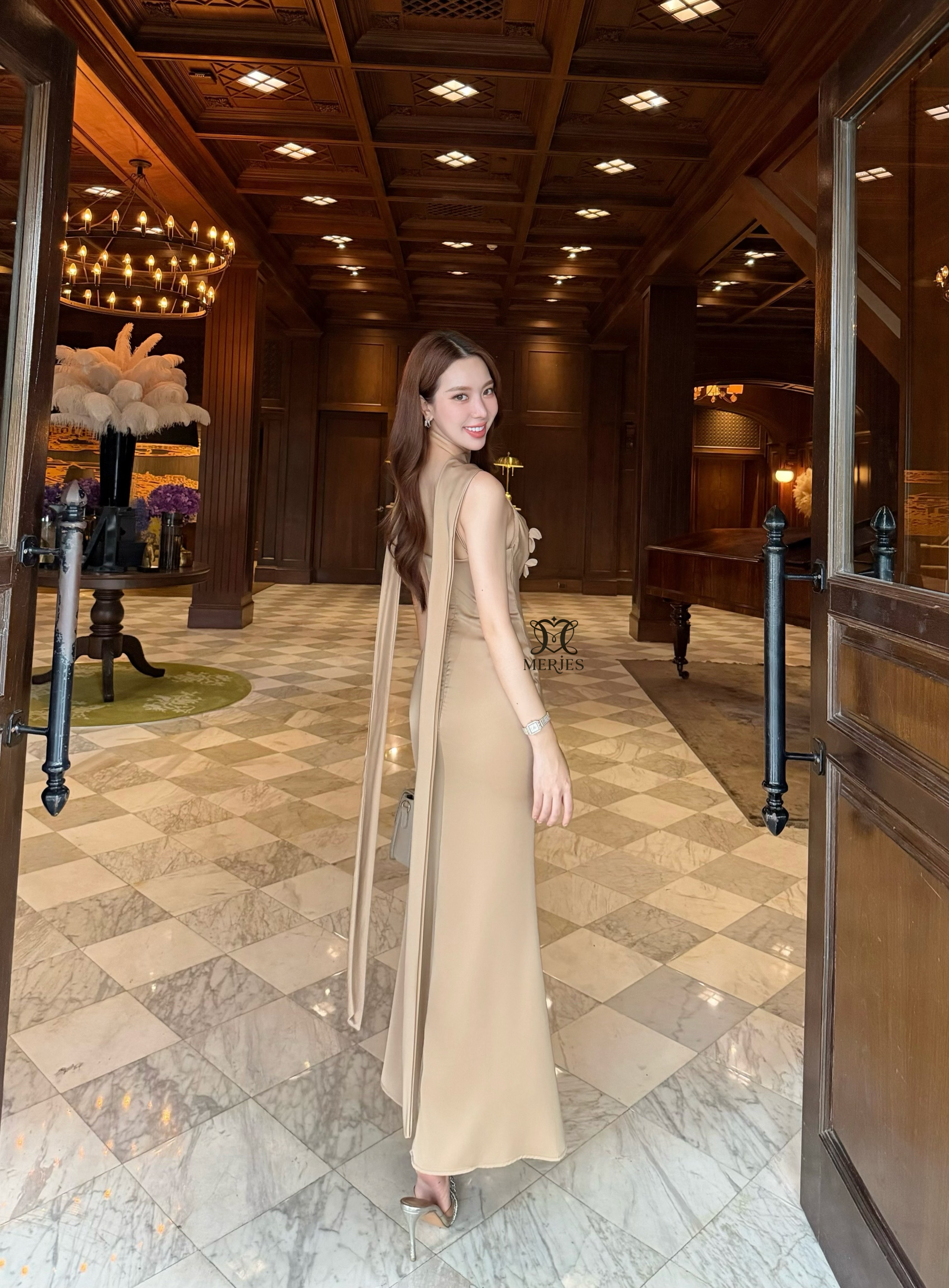 𝐌𝐄𝐑𝐉𝐄𝐒 𝐒𝐓𝐔𝐃𝐈𝐎 (เมอร์เจส) 𝐃𝐞𝐭𝐚𝐢𝐥 : เดรสยาวสีน้ำตาลทองผ้าซาตินสายเดี่ยวเข้ารูปสายสามารถปรับได้แต่งดีเทลด้วยดอกไม้