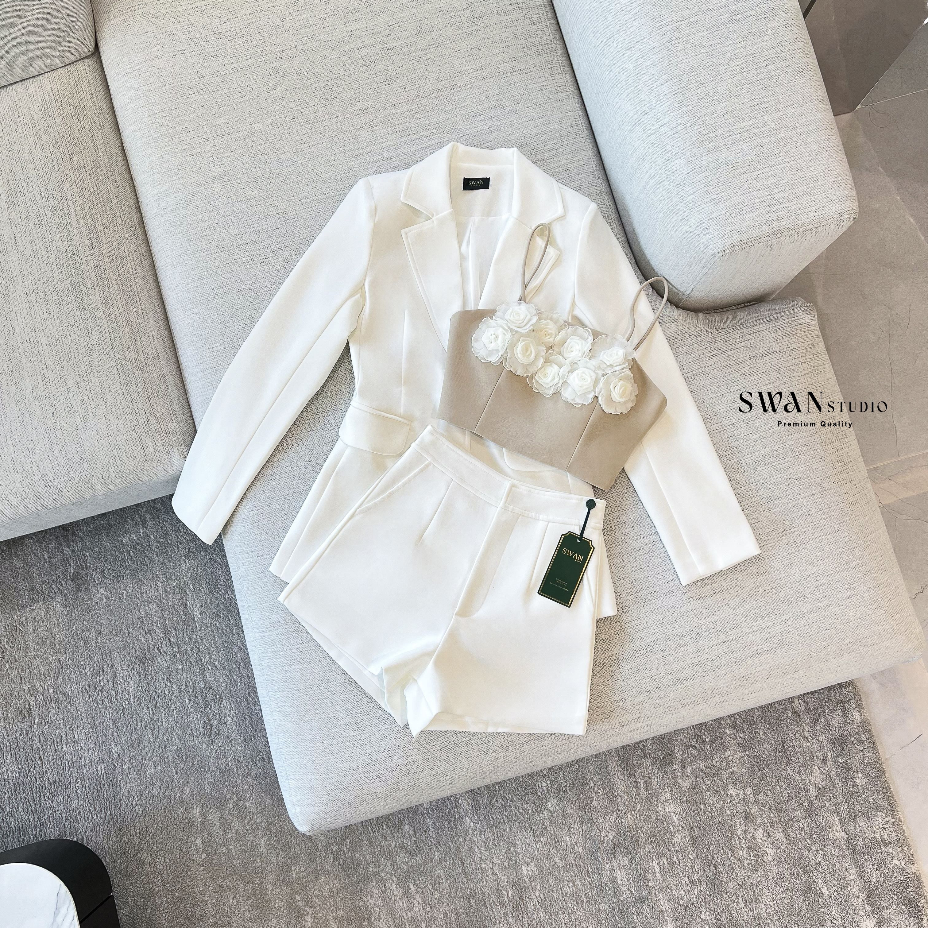 Set 3 ชิ้น ประกอบด้วยเบลเซอร์แขนยาวทรงเข้ารูป มิกซ์เข้ากับกางเกงขาสั้นเอวสูงที่ช่วยให้ลุคดูขาเรียวยาว ด้านในแมทช์กับเสื้อครอปสายเดี่ยวโทนเบจตกแต่งดอกกุหลาบสามมิติสีขาวเรียงแถวด้านหน้าอย่างประณีต