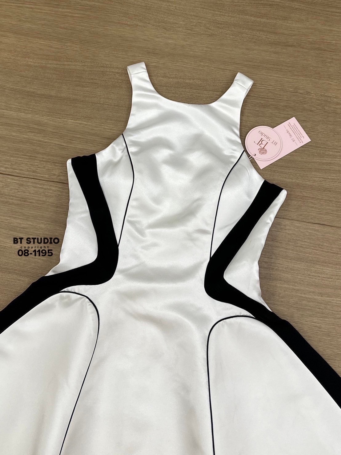 เดรสสั้นแขนกุด ด้านหลังเว้าแต่งสายสีขาว ดีเทลแต่งลายสีดำตัดขอบเว้า แต่งกุ้นเส้นเล็กๆ พรางหุ่นสุดๆ ช่วงอกเสริมฟองน้ำ ตัวกระโปรงบานออก ซิปหลัง มีซับใน เนื้อผ้ามันเงาใส่แล้วออร่าม๊ากก งานสวยคุณค่าที่เราคู่ควรคร้า #BTstudio #ป้ายBt #แบรนด์บีที #งานป้ายBtstudi