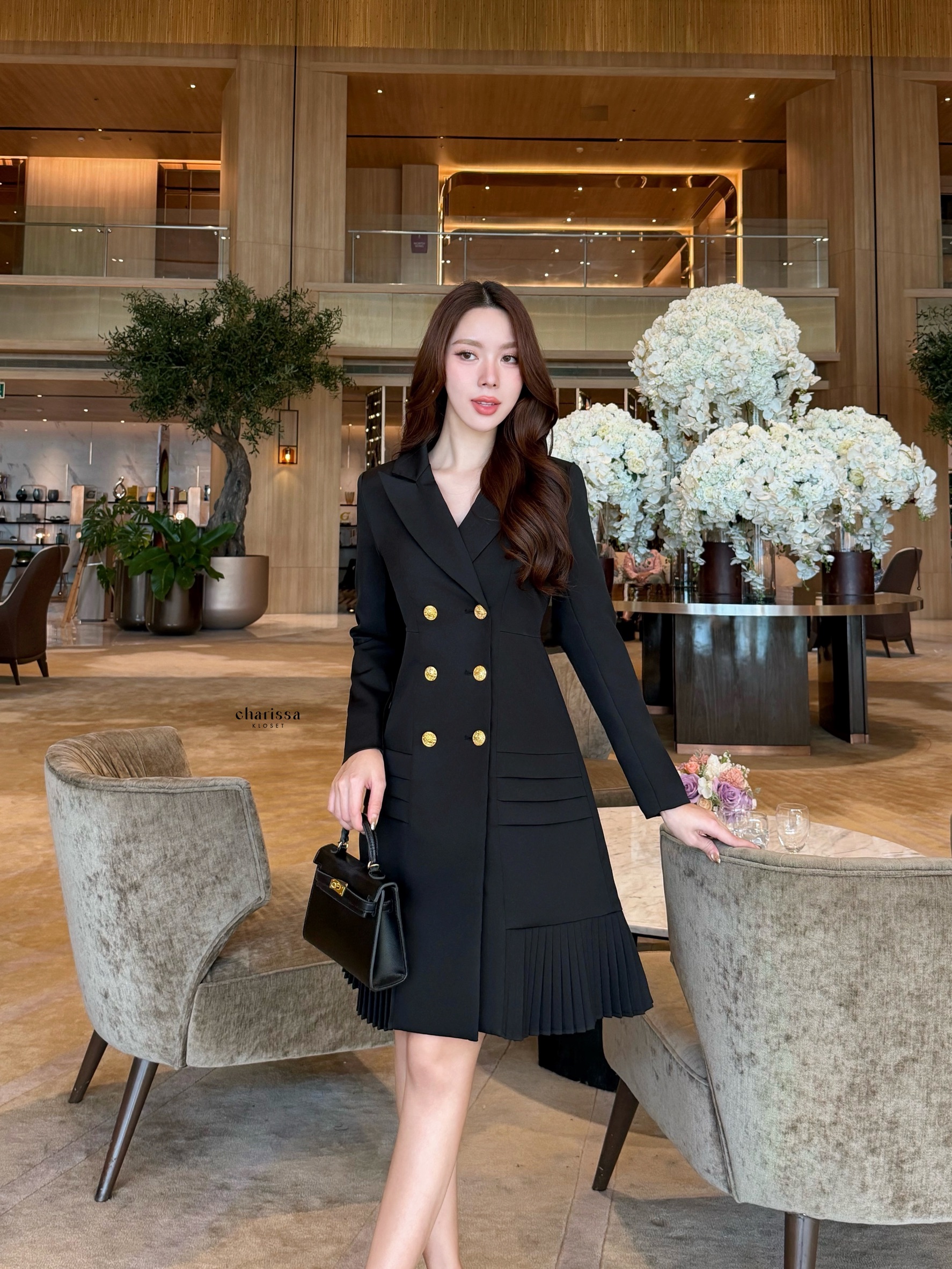 เดรสสูทกระดุมทองทรงหรู สไตล์มินิมอลคลาสสิกที่ออกแบบมาเพื่อเสริมความสง่างามทุกอิริยาบถ ตัวชุดเป็นทรง double-breasted เข้ารูปกำลังดี เน้นสัดส่วนช่วงเอวให้ดูเพรียว เรียบหรูแต่ทรงพลัง กระโปรงด้านล่างตัดต่อด้วย ดีเทลพลีท (Pleated Hem)