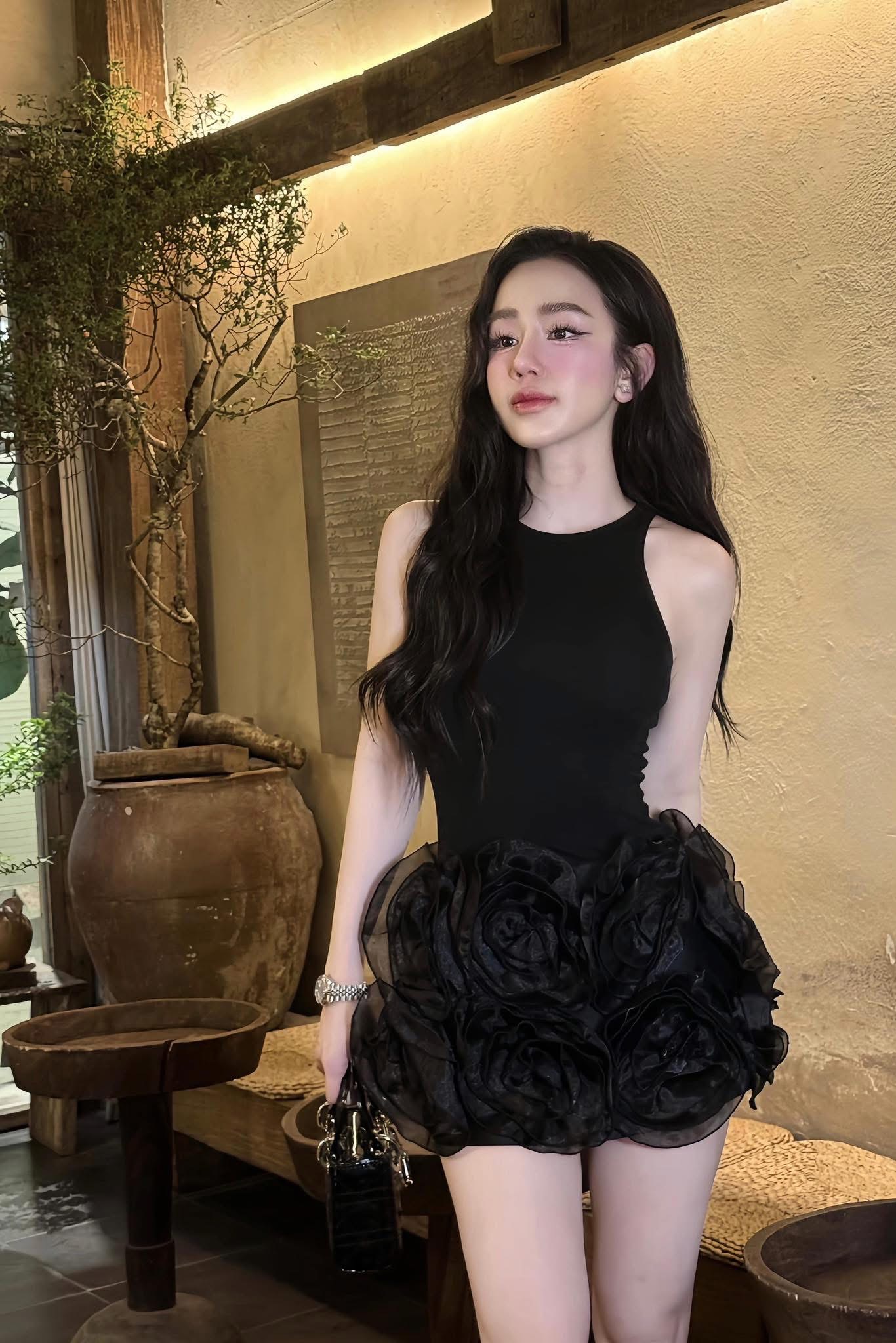เดรสสายแขนกุดสีดำทรงเข้ารูป เนื้อผ้ายืดกระชับเก็บทรงสวย ใส่แล้วหุ่นเป๊ะเวอร์ ไฮไลต์ของชุดคือกระโปรงที่แต่งด้วยดอกกุหลาบขนาดใหญ่แบบ 3 มิติด้านหน้า เพิ่มความหรูหราและโดดเด่นไม่ซ้ำใคร ทรงชุดเรียบหรูด้านบน ตัดกับดีเทลล่างได้อย่างลงตัว ลุคนี้ใส่แล้ว