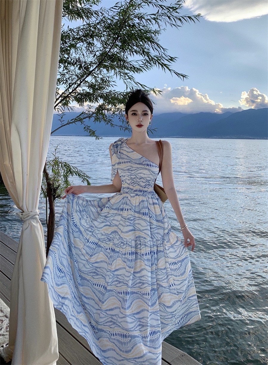 Maxi เดรสไหล่เดียว แต่งสายผูกโบว์ช่วงไหล่ ช่วงเอวเป็นสม๊อค เข้ารูปสวย ตัวกระโปรงแต่งระบายบานออก พริ้วๆ งานสวย เนื้อผ้าพิมพ์ลายโดดเด่น มีชับใน ซัมเมอร์นี้ห้ามพลาด