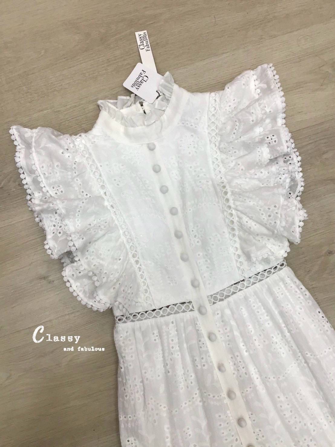 เดรสผ้าลูกไม้ลายฉลุทั้งตัว คอปีนมีระบายรอบคอ และเป็นกระดุมด้านหลังคอ แขนทำระบาย2ชั้นปิดต้นแขนและมีวงกลมเล็กๆที่ปลายแขน ตรงกลางชุดติดกระดุมไล่ลงมาจากอกถึงปลายกระโปรง ช่วงกระโปรงทรงสวยมาก