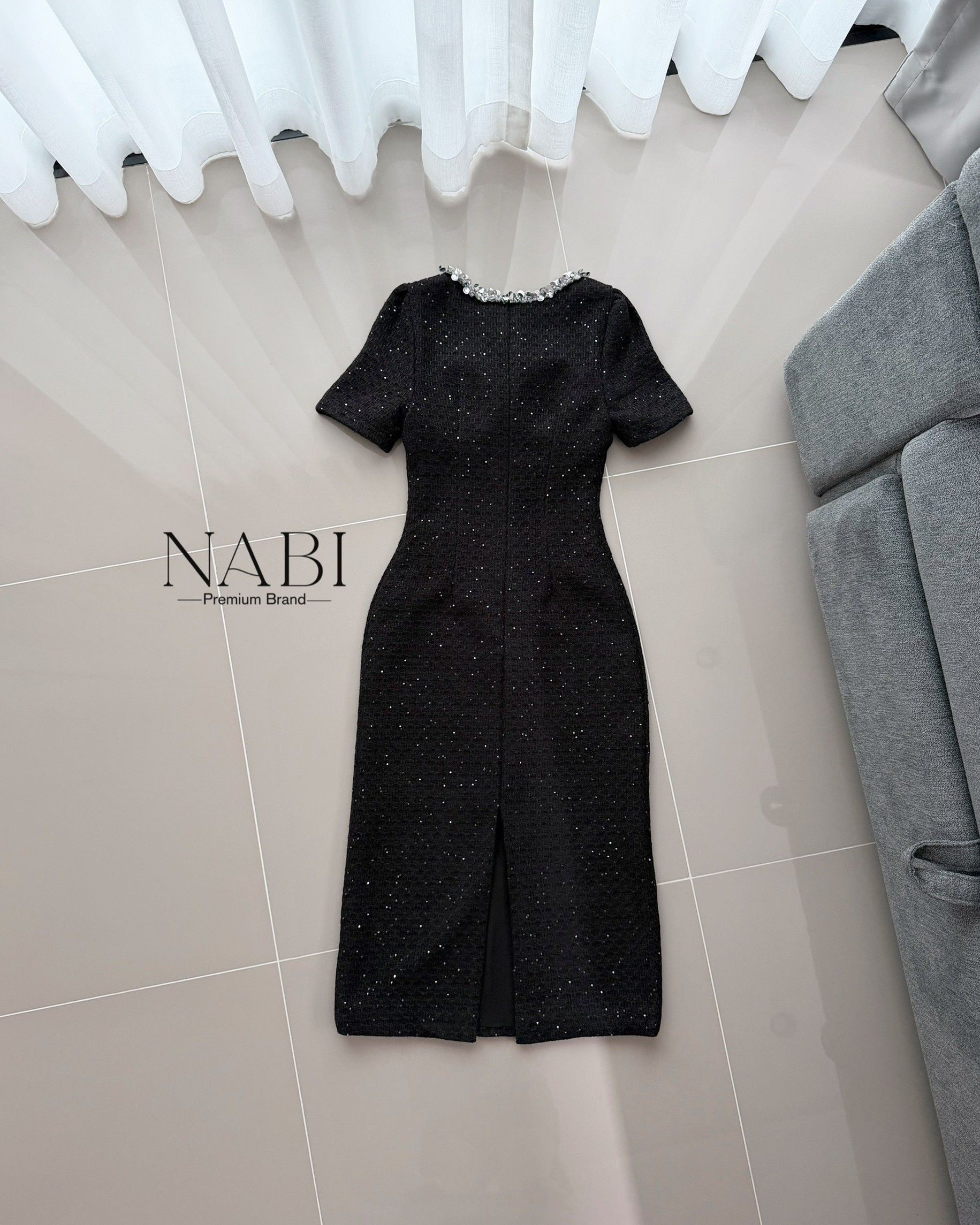 ชุดเดรสทรงเชฟเข้ารูปแขนสั้น ความยาวมิดเข่า ดีไซน์คอกลมตกแต่งมุกคลิตเตอร์เป็นแถบล้อมรอบคอ และแต่งผ้าซีทรู ใช้ผ้าทวีดเนื้อหนาที่มีพื้นผิว ประดับด้วยเม็ดกลิตเตอร์เล็กทั่วผืน ให้ประกายเป็นจุด ๆ เรียบแต่หรูดูแพง มีซับในและฟองน้ำ งานซิปซ่อนด้านหลัง ผ่าด้านหลัง