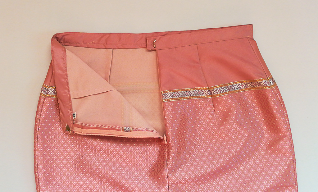 ผ้าถุงไหมสำเร็จรูป (สีชมพูอ่อน ลายสุโขทัย ทรงกระโปรง) งานตัดเย็บประณีต อัดผ้ากาวตามสีของผ้าถุง เนื้องานดีเกรด A (รอบเอว 30 นิ้ว)