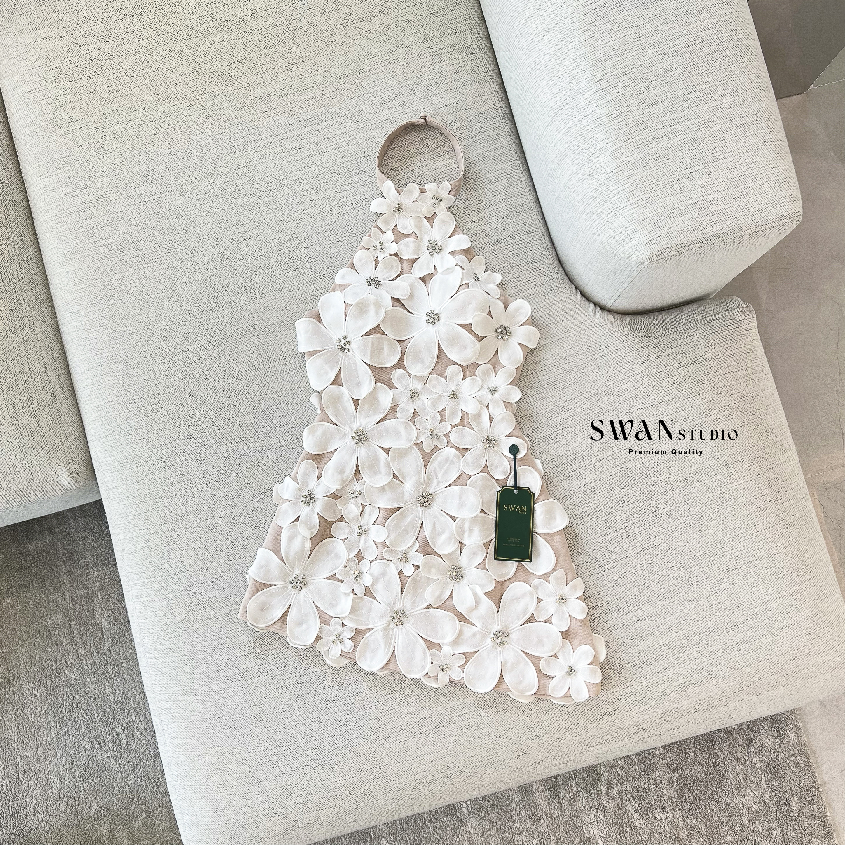 เดรสสั้นดีไซน์สุดโดดเด่นด้วยลายดอกไม้สามมิติทั้งตัว แต่งดอกไม้นูนขนาดเล็ก-ใหญ่ไล่ระดับจากช่วงคอลงมาถึงชายกระโปรง เพิ่มลูกเล่นด้วยการฝังคริสตัลเล็กกลางดอกช่วยสะท้อนแสงอย่างหรูหรา ดีไซน์ชายเดรสเฉียงดูชิคเปรี้ยวมาก ให้ลุคหวานปนเซ็กซี่อย่างลงตัว เ